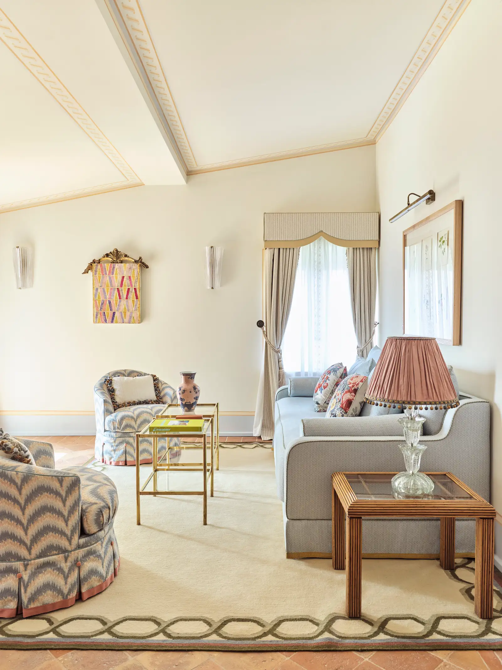 The San Fruttuoso Suite’s living room, with the grey sofa, zigzag armchairs and white ceiling beams.
