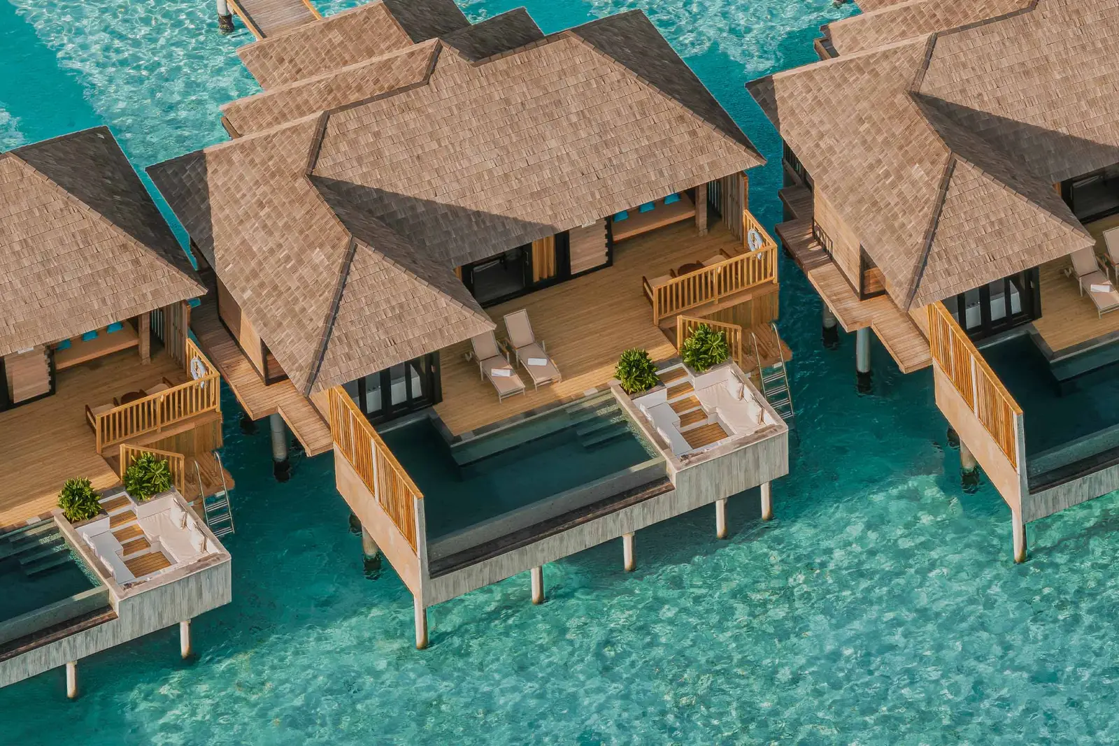 The Horizon Water Villas with Pool from above, side by side, with their decks and ladders into the turquoise.