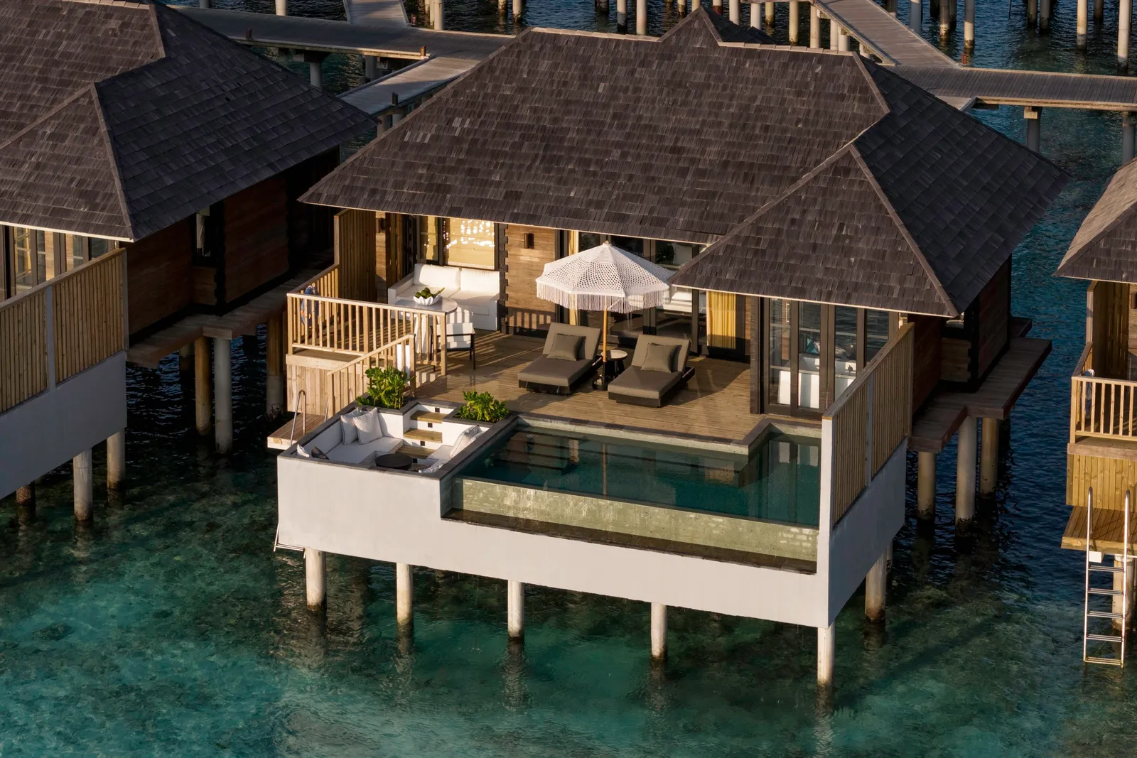 A Horizon Water Villa with Pool from above, its pool and loungers on the deck over the sea.