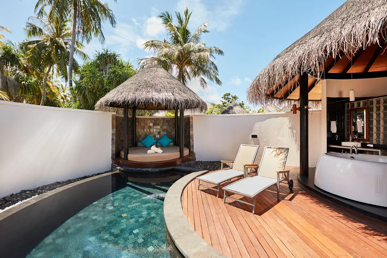 The Private Pool Beach Villa: the curved pool in the garden, the thatched cabana and the timber deck.