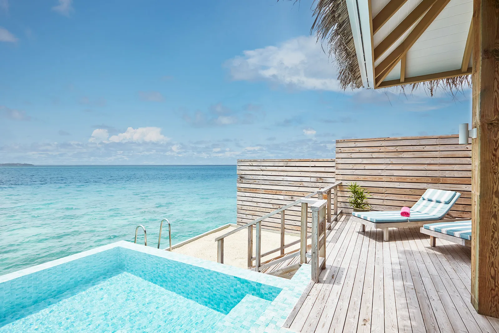 A Dolphin Ocean Villa with Pool’s infinity pool on the timber deck, with the open sea beyond.