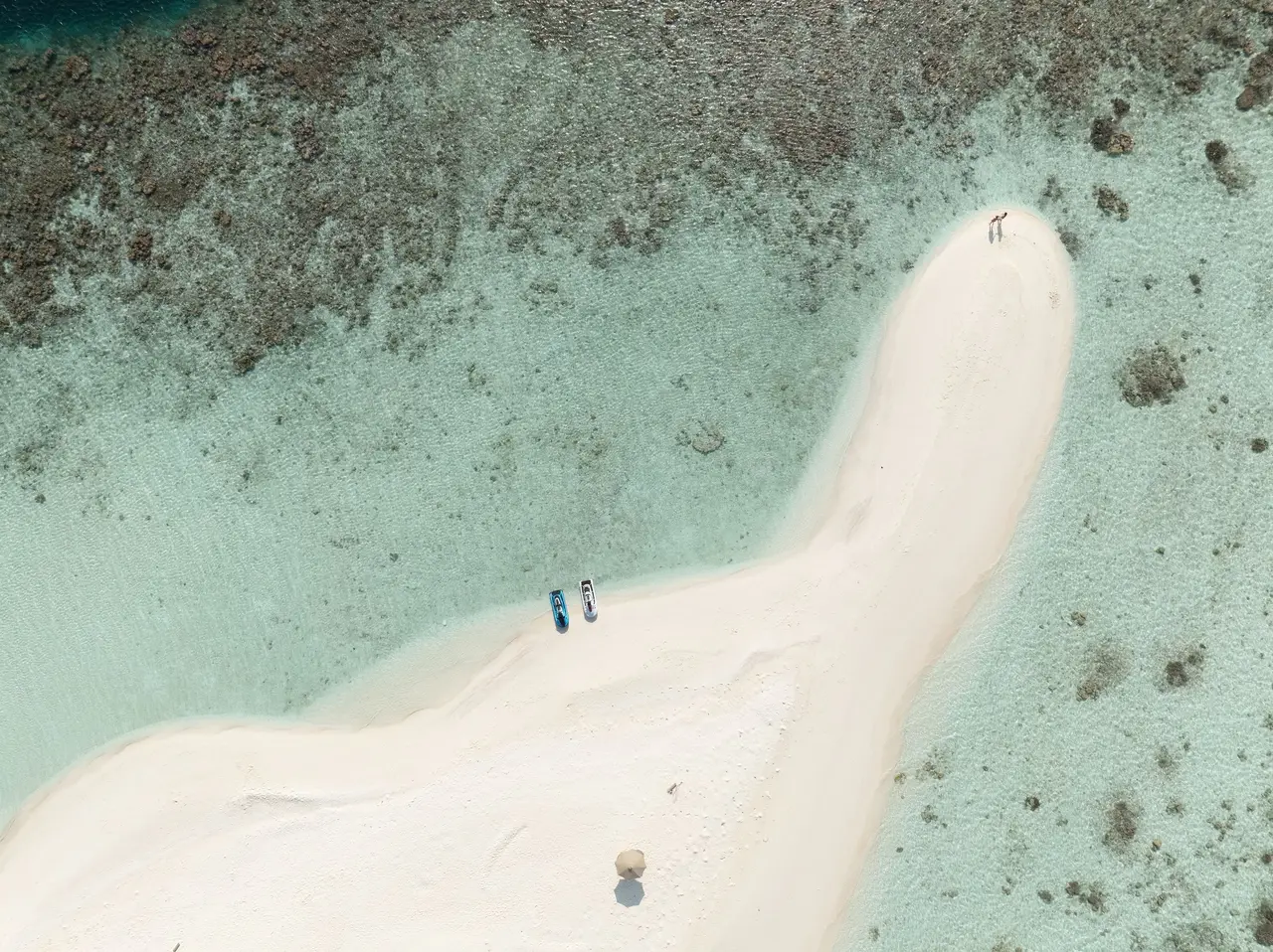 A sandbank in the lagoon from above, 2 people at the water’s edge