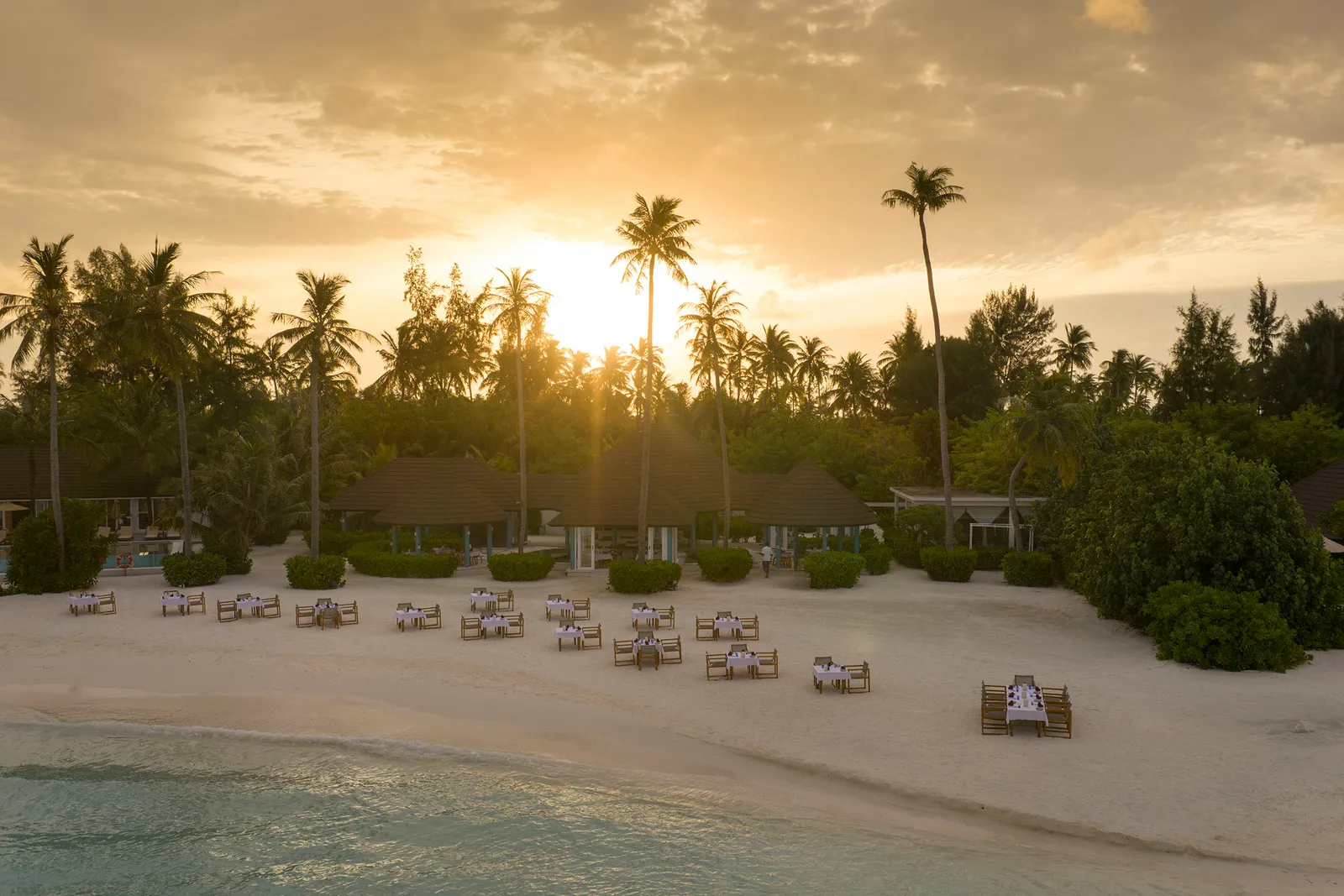 Maghrib Grill’s tables on the sand at sunset