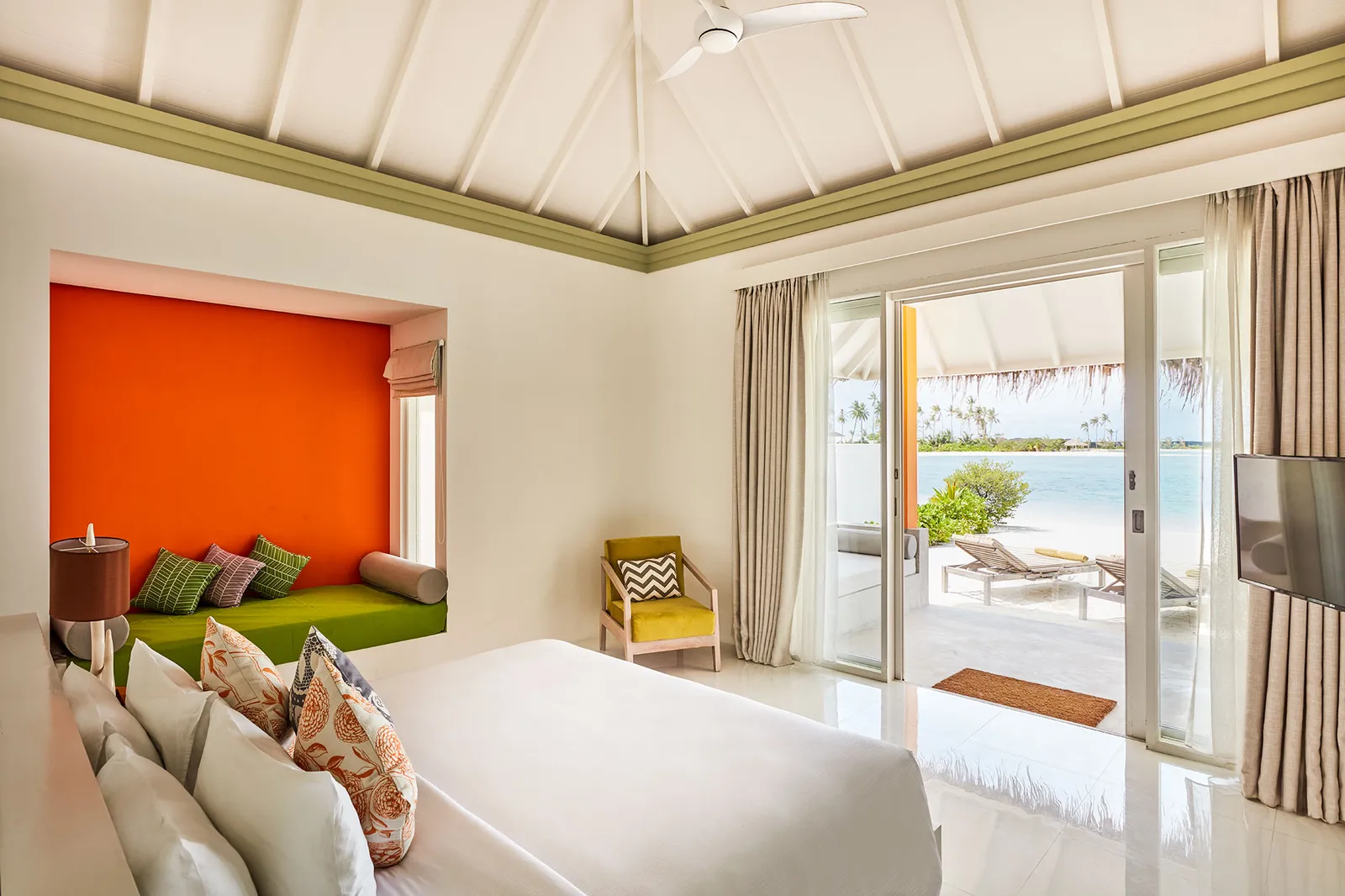 Inside a Grand Beach Villa, the bed and the door open onto the beach