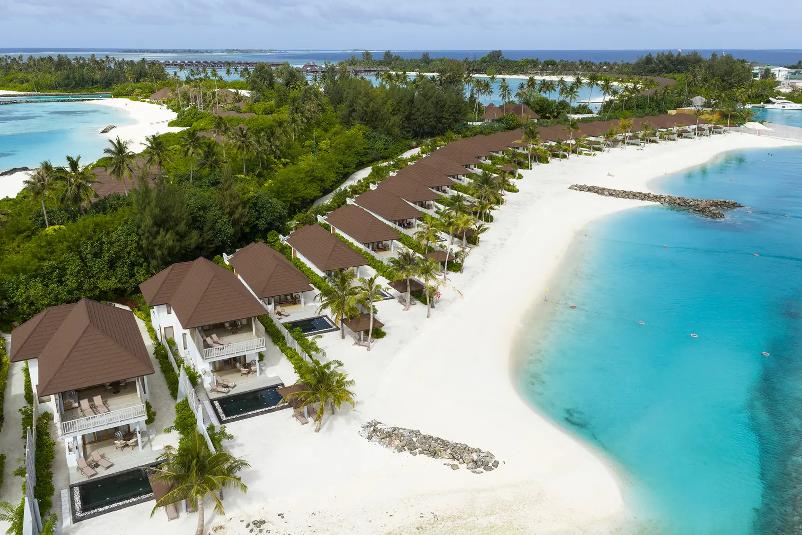 The beach villas from above, in a row along the sand and the lagoon