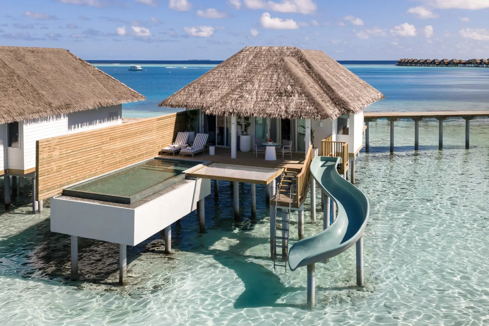 An Ocean Signature Villa on the lagoon, with its raised pool and the green slide curling down to the water.
