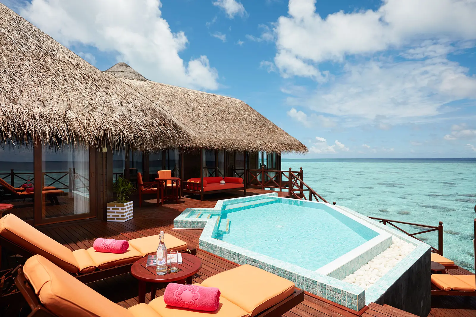The Two Bedroom Water Villa with Pool’s deck, with its pool, loungers and the neighbouring water villas.