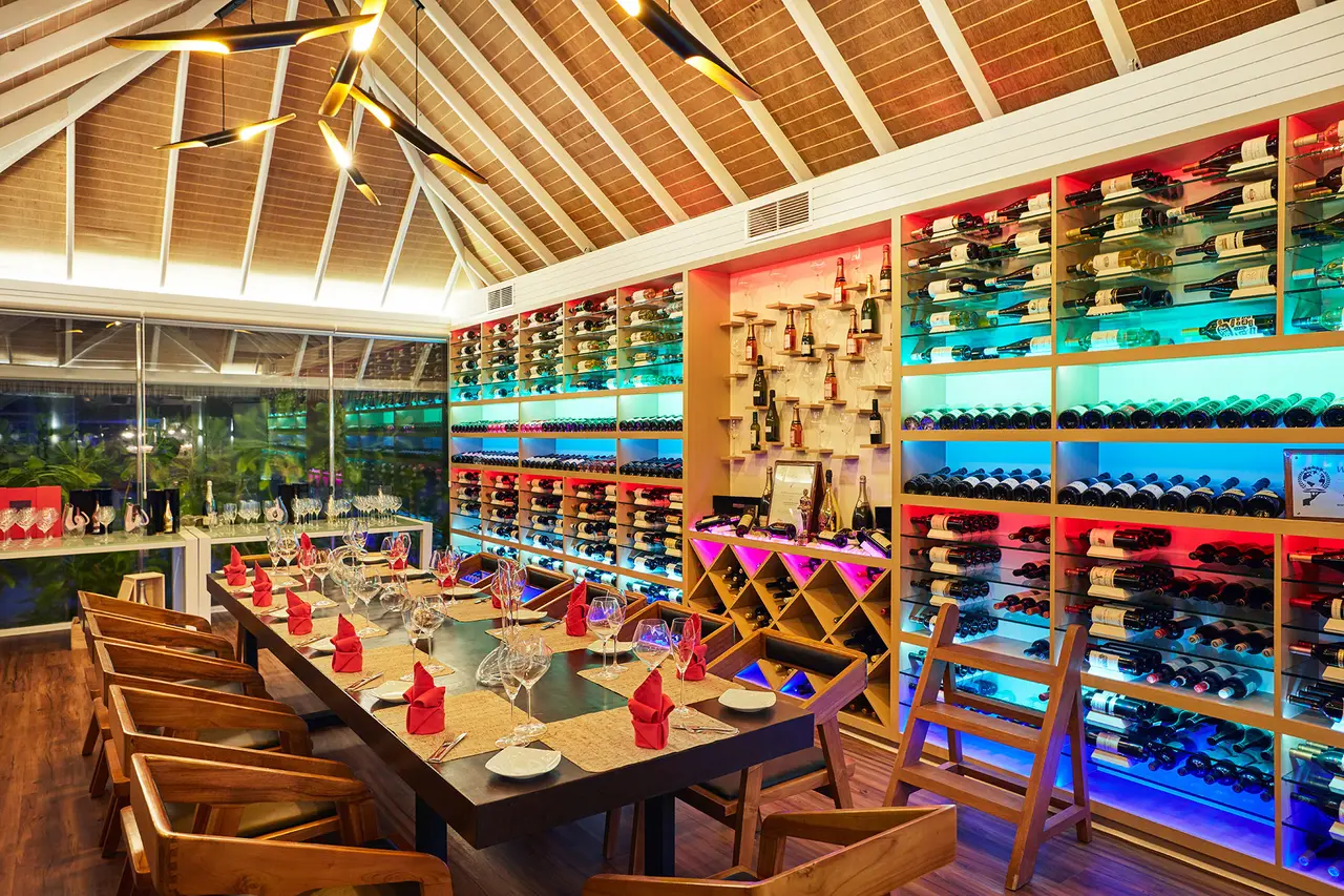 The Wine Cellar: the table laid for a private dinner in front of walls of lit bottles.