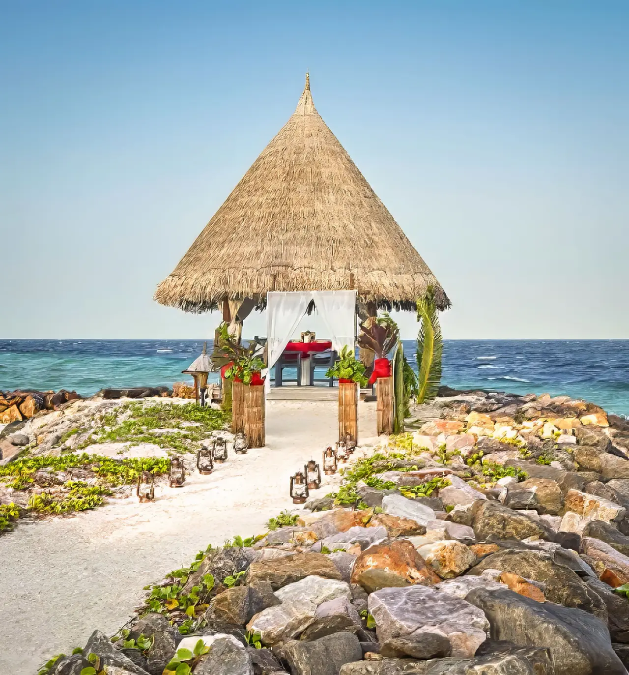 A thatched pavilion on the tip of the breakwater, dressed for a dinner or a ceremony, the sea all around.