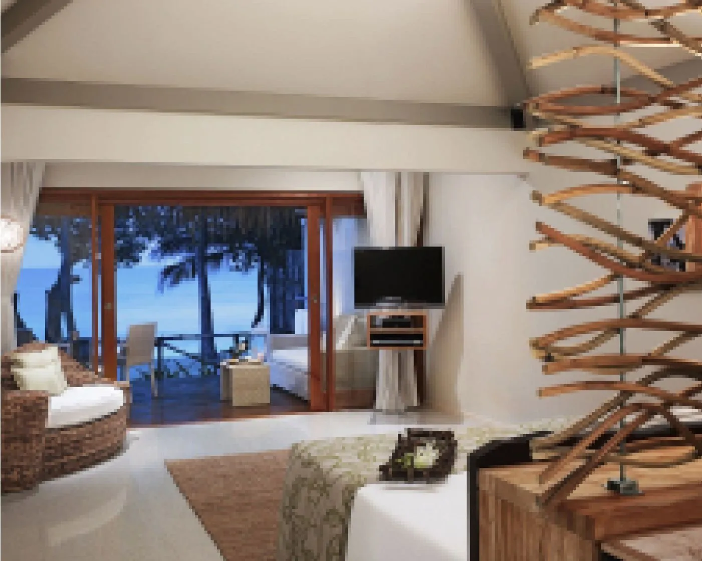 A Deluxe Beach Villa bedroom: the bed, the wicker sofa and the big bay window onto the beach and the sea.