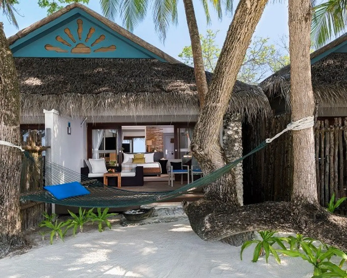 A Superior Beach Villa among the palms, with a hammock on the sand and the veranda open.