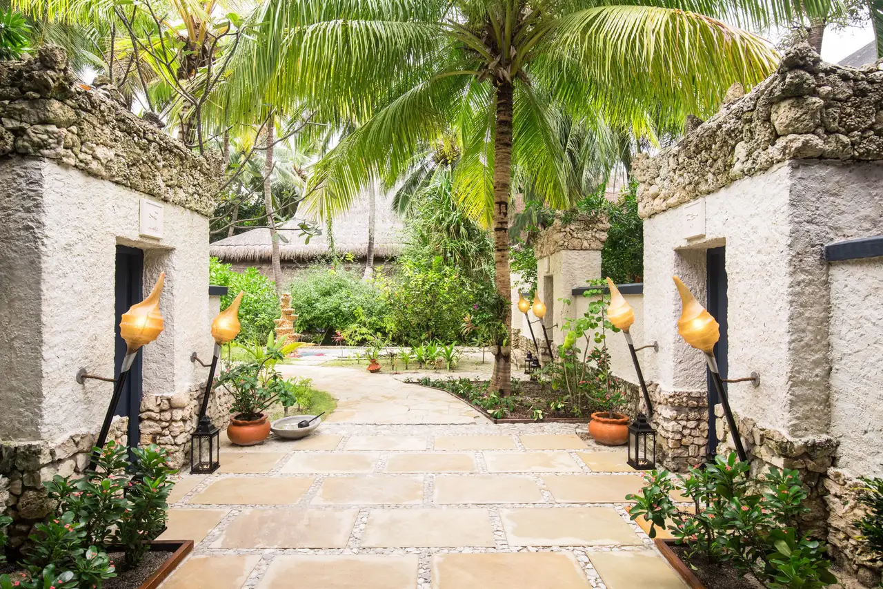 The stone path to the spa, between coral-stone walls, torches and coconut palms.