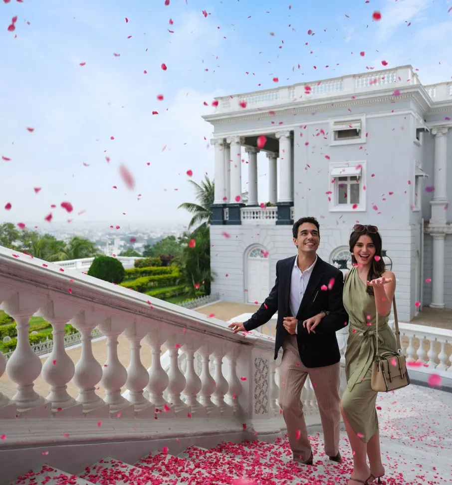 Una coppia sulla balaustra del palazzo sotto una pioggia di petali di rosa