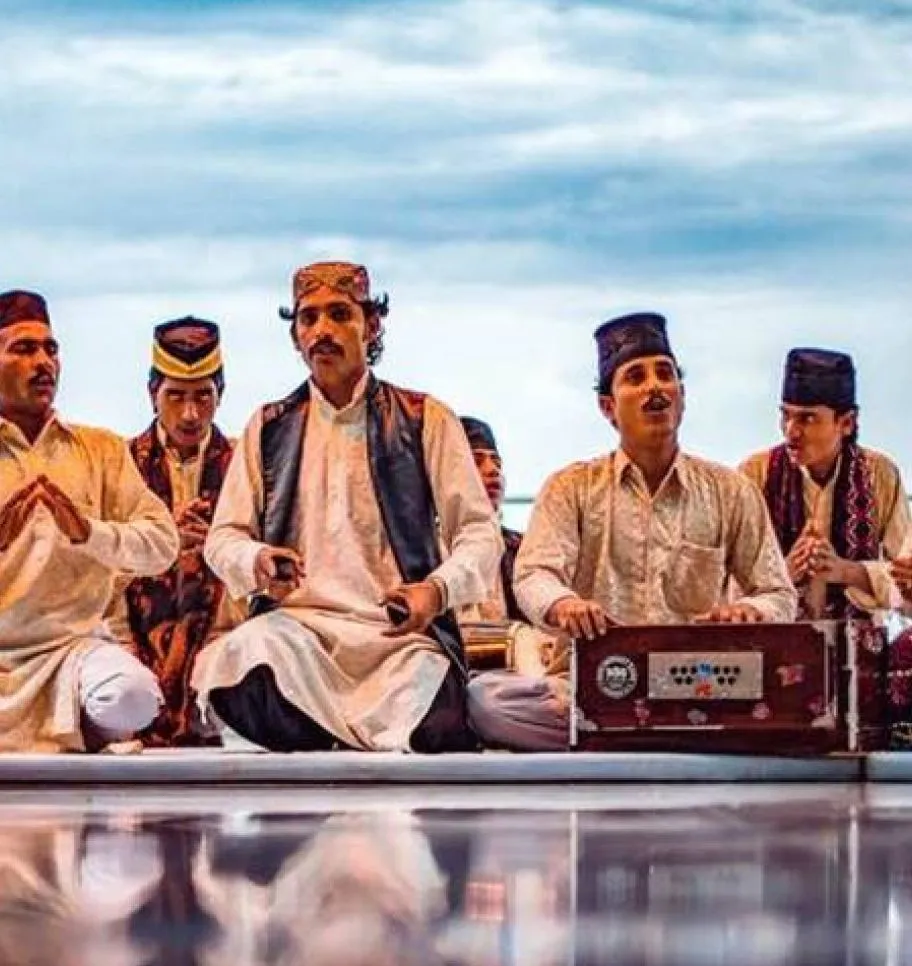 Un gruppo di musicisti qawwali seduti con l’armonium