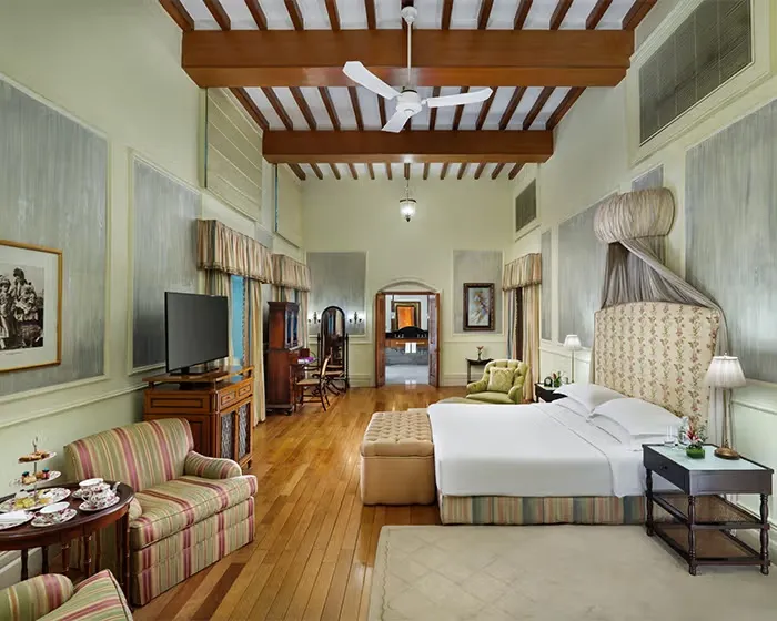 Una Luxury Room con soffitto a travi, letto bianco e un divano a righe