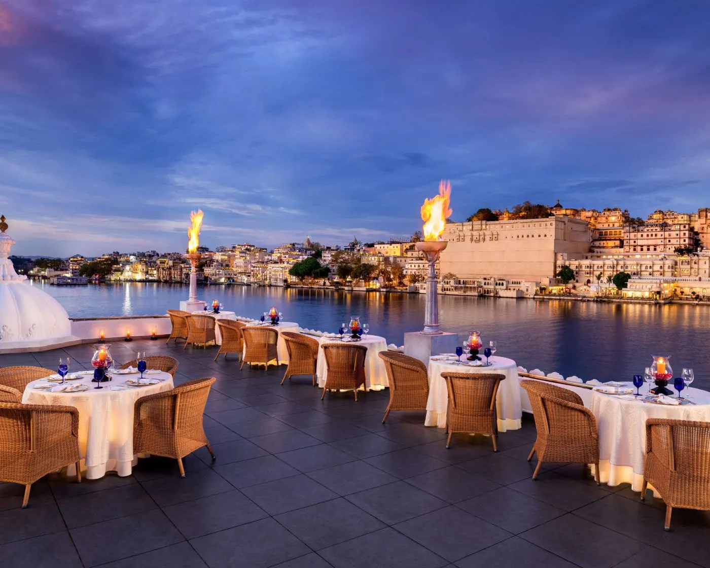 Bhairo’s empty terrace: laid tables, flame torches and the City Palace across the lake