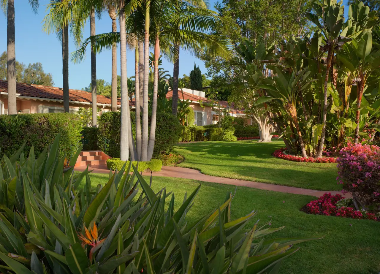 The lawns and palms between the bungalows, the pink cottages with tiled roofs