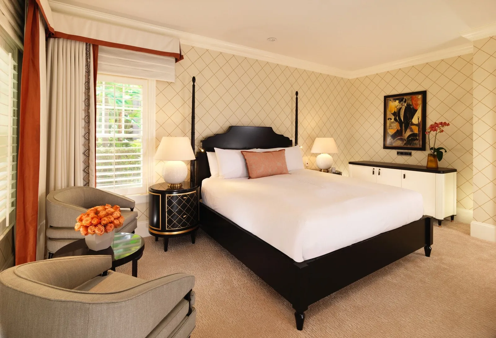 A Bungalow King room with its bed and leaf-pattern wallpaper