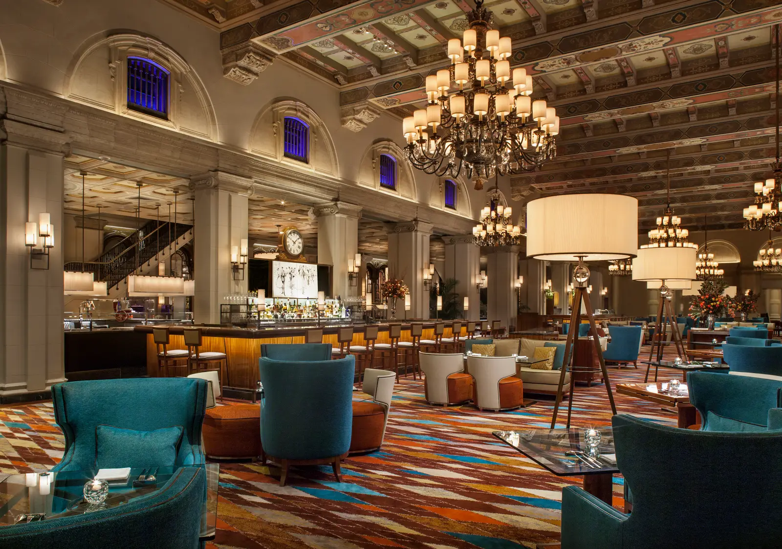 HMF: the painted coffered ceiling, chandeliers, the bar counter and blue armchairs on a patterned carpet.