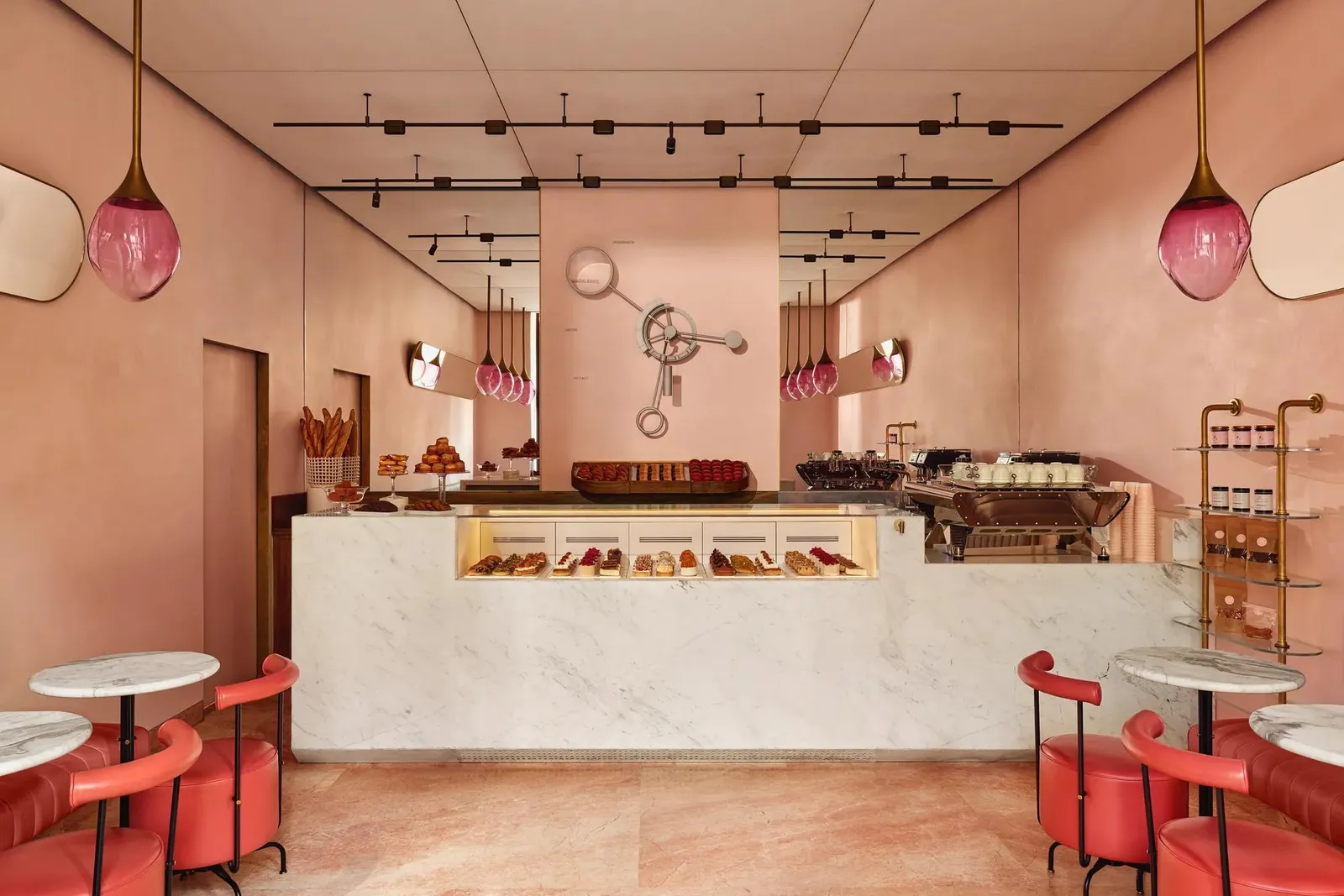 Nicolas Rouzaud’s pâtisserie: pink walls, a marble counter of pastries and red stools