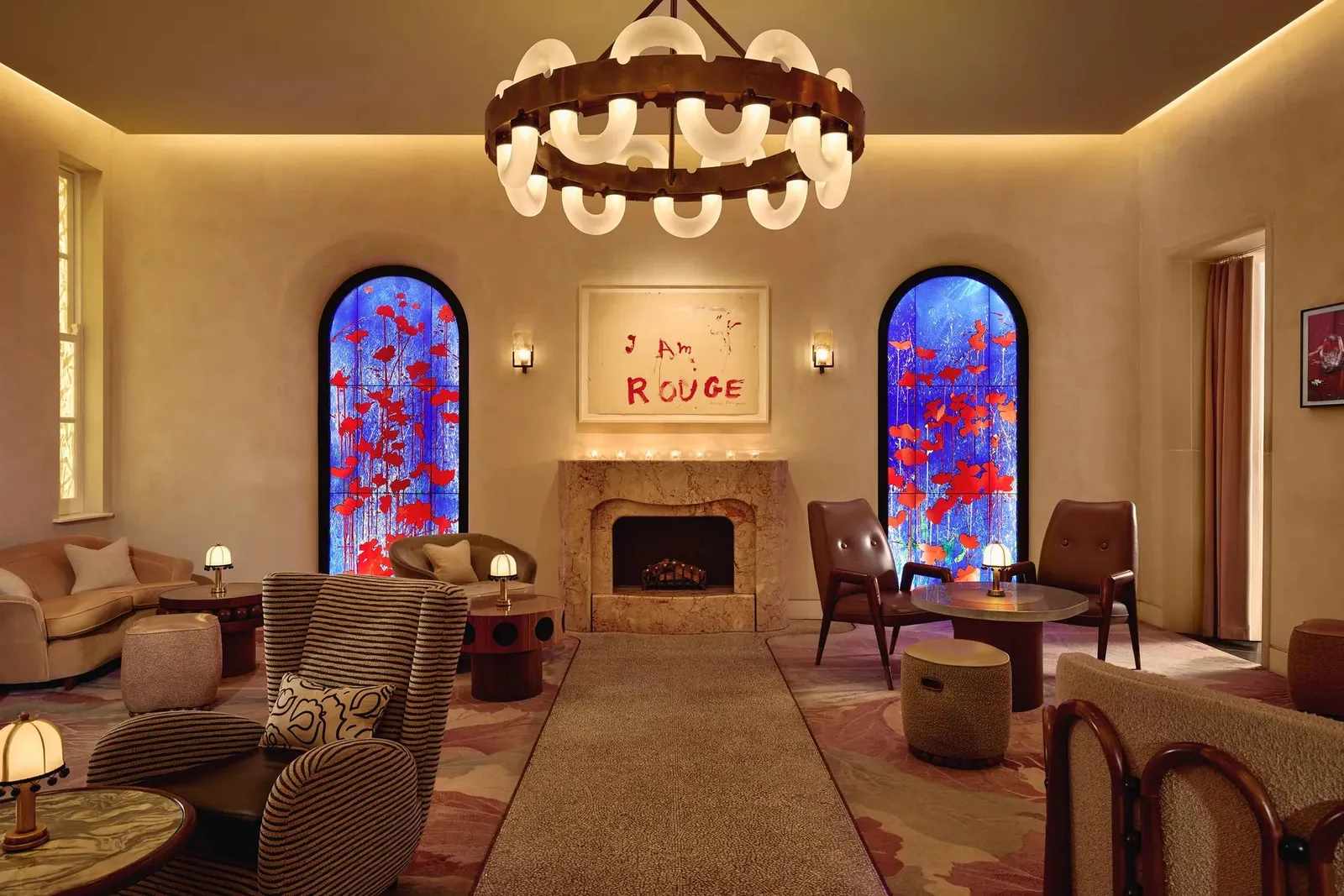 The Red Room: red and blue stained glass, a work reading “I Am Rouge” above the fireplace and low armchairs