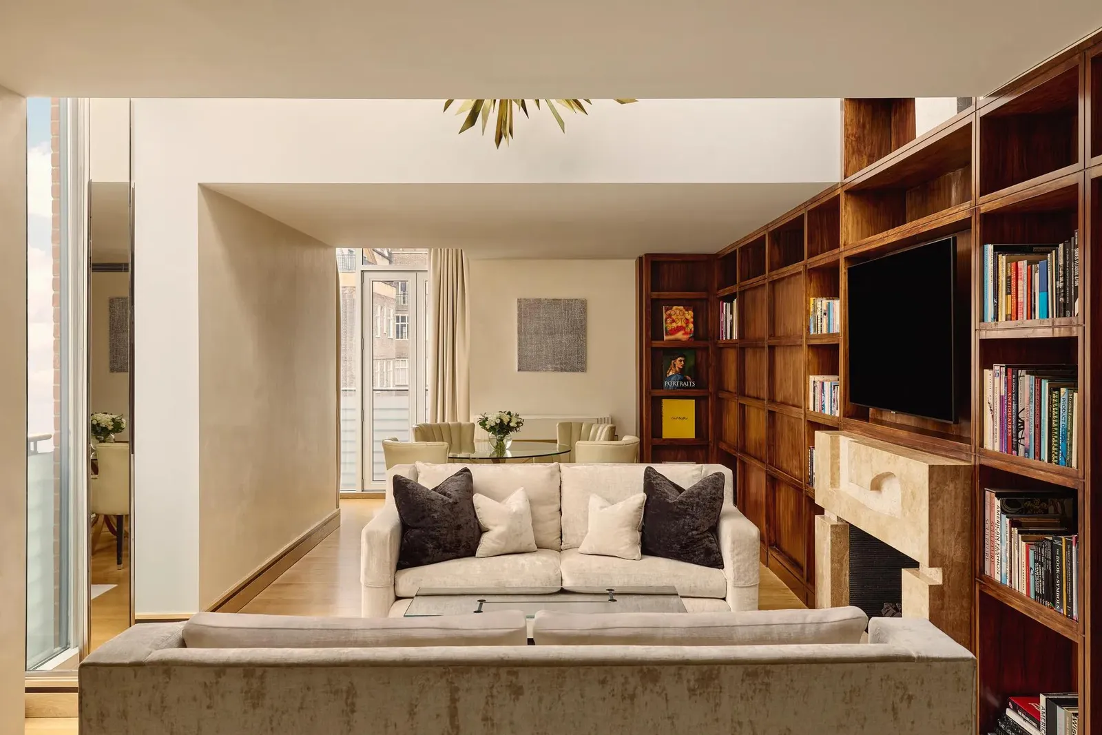 The Library Suite: a wall of wooden bookshelves, a stone fireplace and a white sofa
