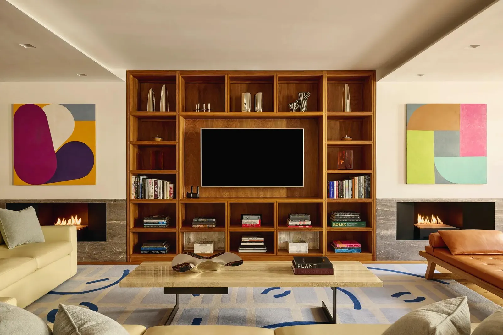 The Mews sitting room: a walnut bookcase, 2 open fireplaces and bright abstract paintings