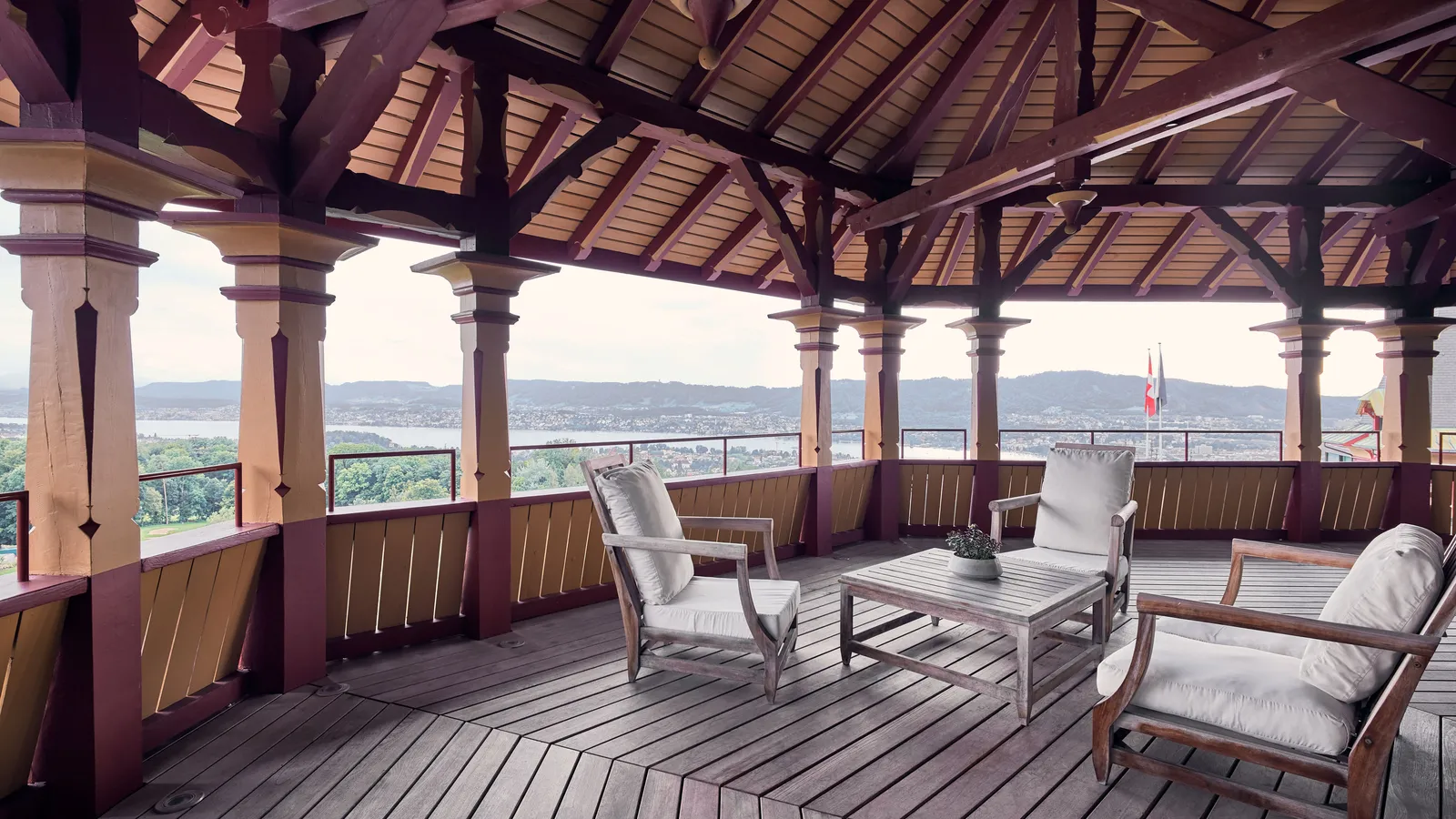 The covered wooden terrace in the tower of the Maestro Suite, with armchairs facing Lake Zurich