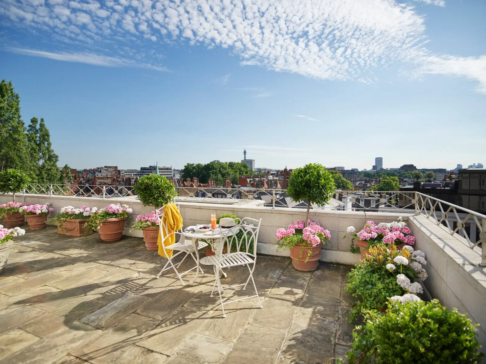 The Oliver Messel Terrace Suite’s terrace, its flower pots and London’s rooftops