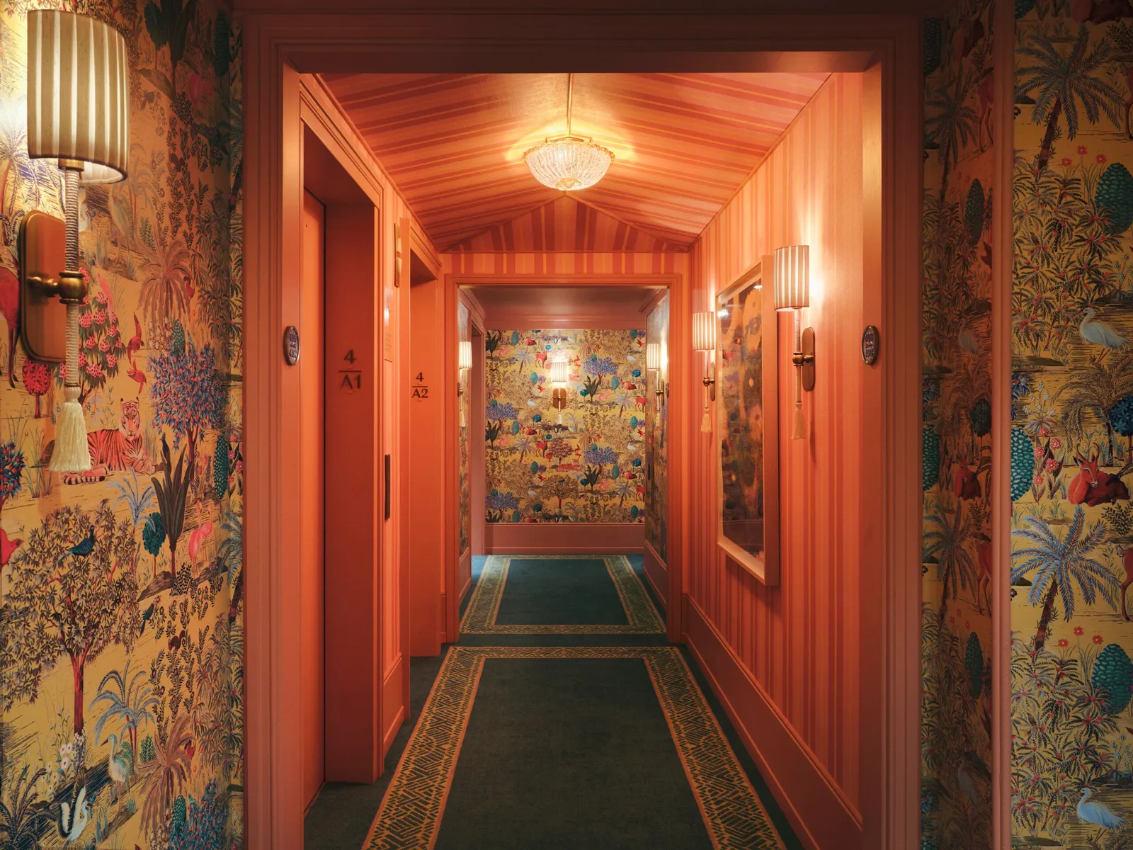 A tower corridor with orange walls, sconces and painted wallpaper at the end