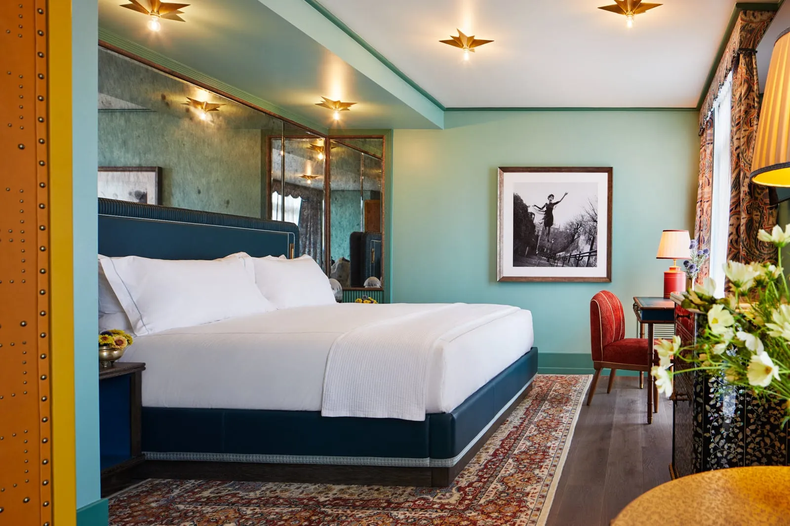 The Grand King with its blue headboard, a green wall and a framed photograph