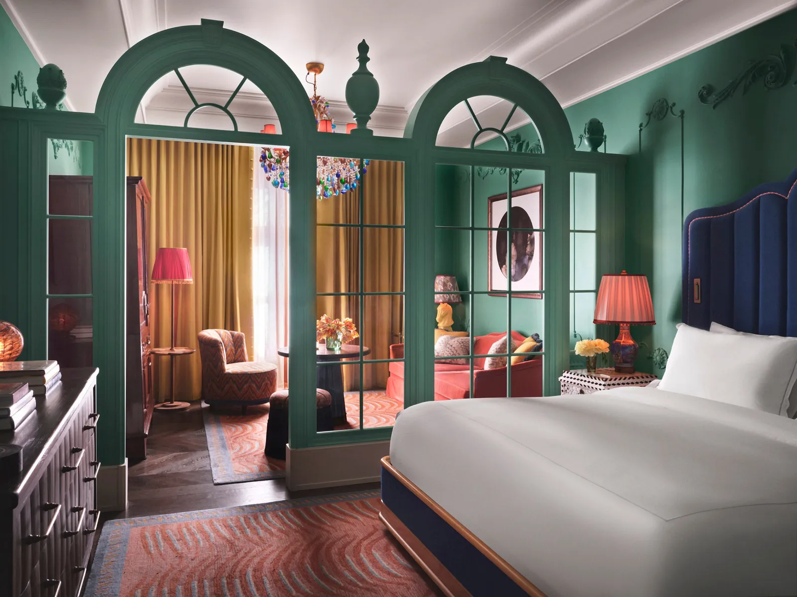The Mansion Suite bedroom framed by green arched doors
