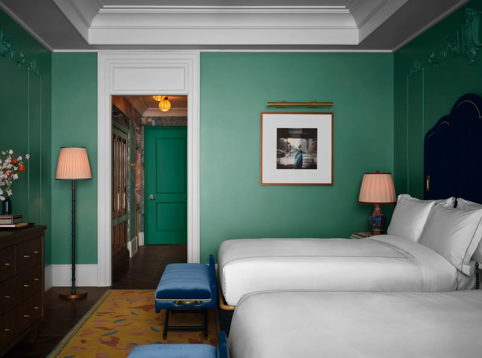 2 queen beds against the green wall of the Mansion Suite Double