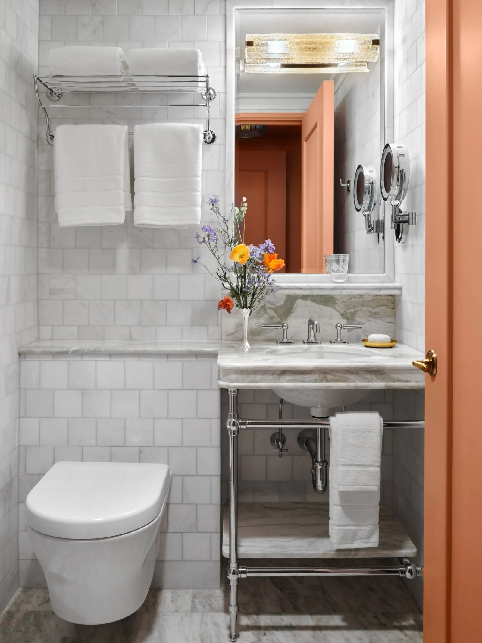 The Nomad Queen bathroom: the basin, white tiles, folded towels