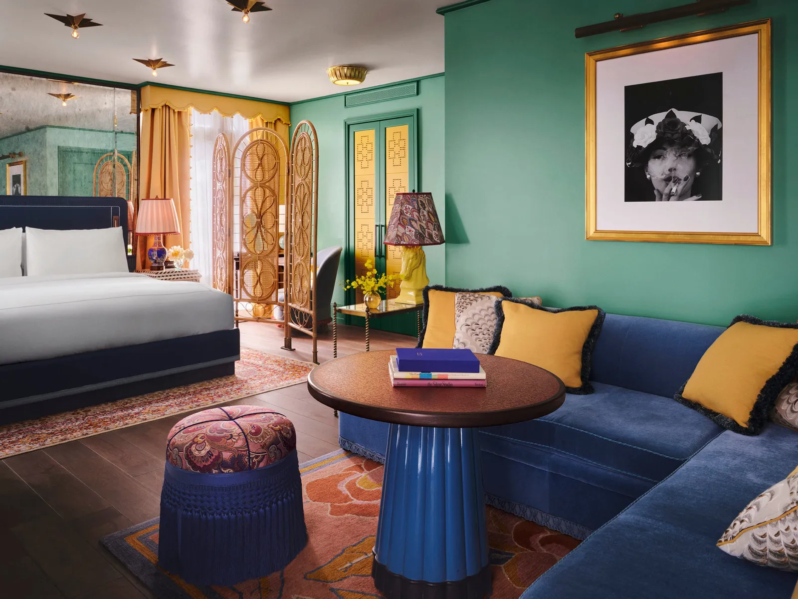 The Studio Suite: a blue sofa round a low table, the bed beyond