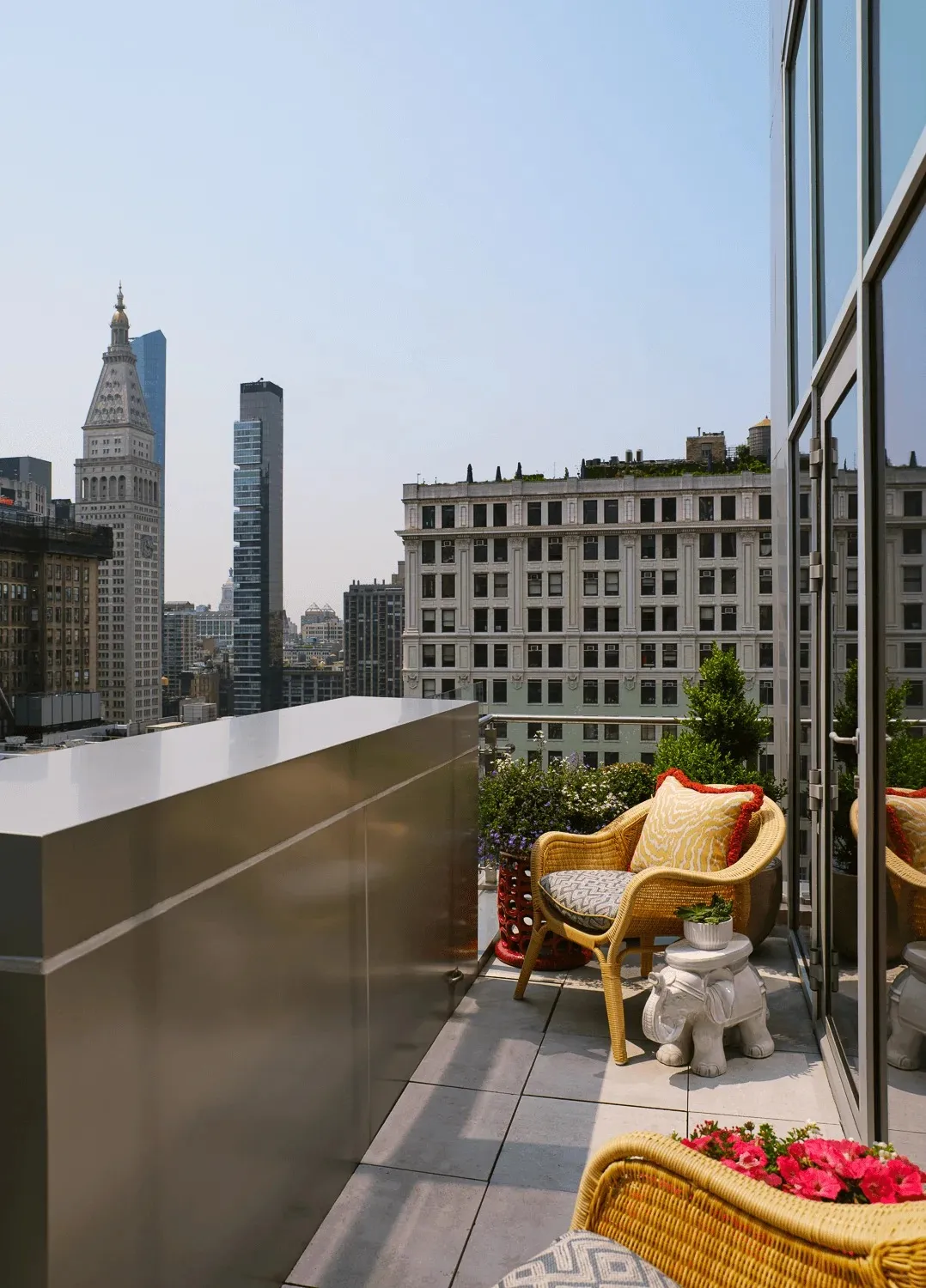 The Studio Suite Terrace’s balcony with a wicker chair and the towers around it