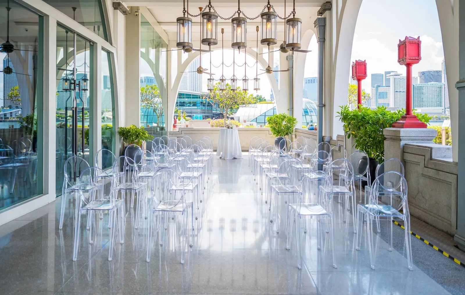 Clifford Pier’s veranda set for a ceremony: rows of transparent chairs, the red lamp posts and the bay beyond.