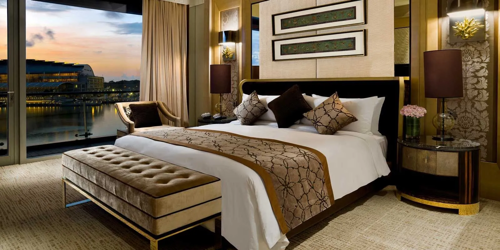 The Presidential Suite’s bedroom: the bed with a bench at its foot and the bay at sunset beyond the window.