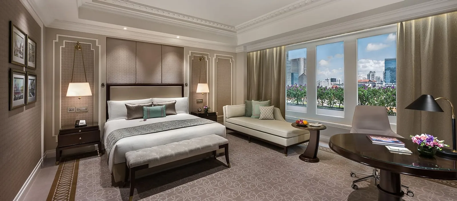 Una Esplanade Room: letto king, divano e una scrivania rotonda sotto un soffitto a cornici, con le finestre sulla vista