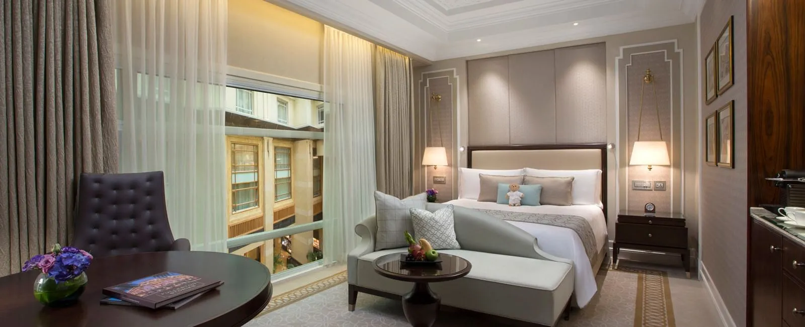 Una Premier Courtyard Room: letto king, chaise longue e un tavolo rotondo accanto a una finestra sull’atrio