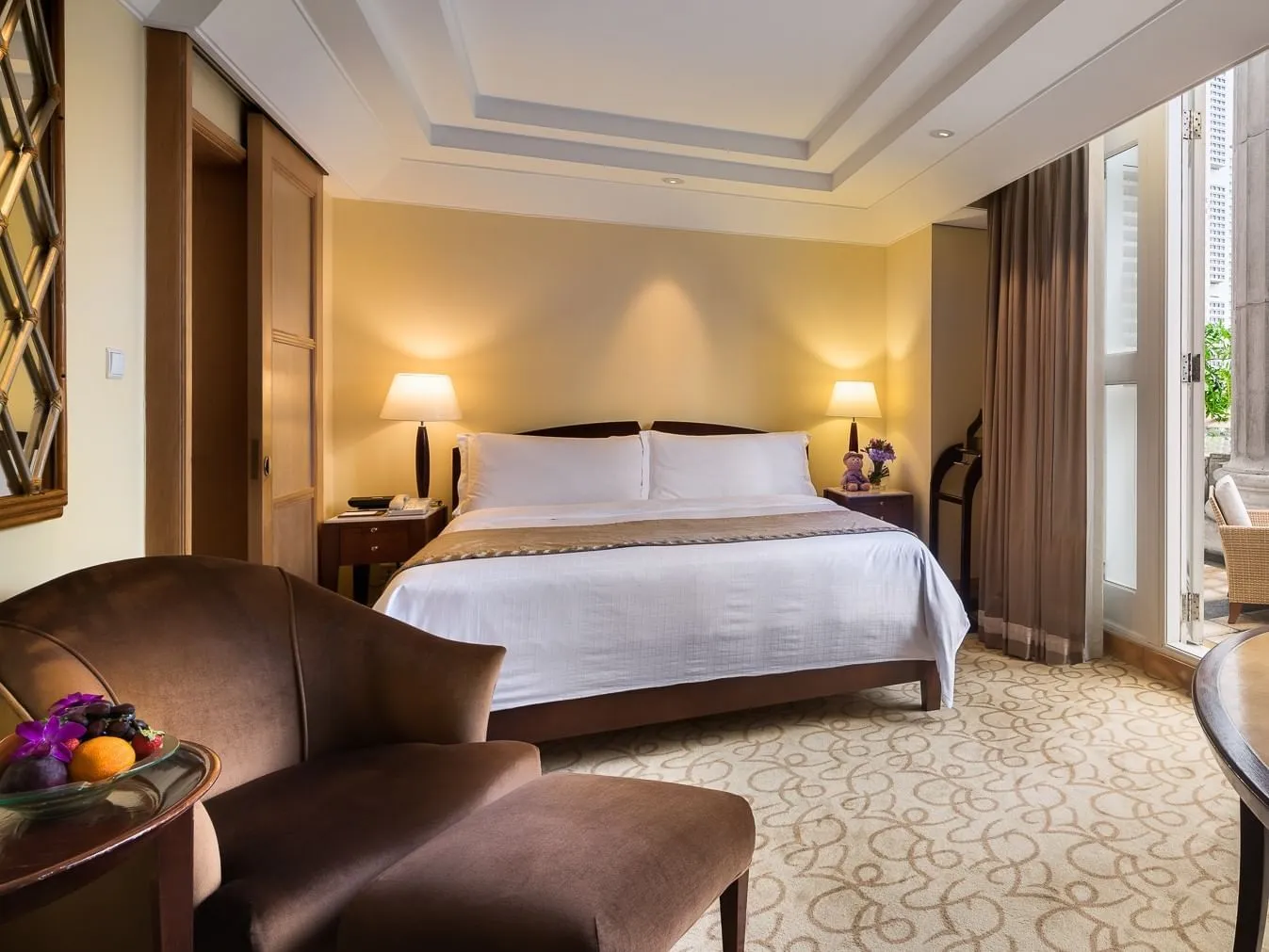 Una Straits Club Quay Room: letto king bianco, poltrone di velluto e la porta del balcone socchiusa