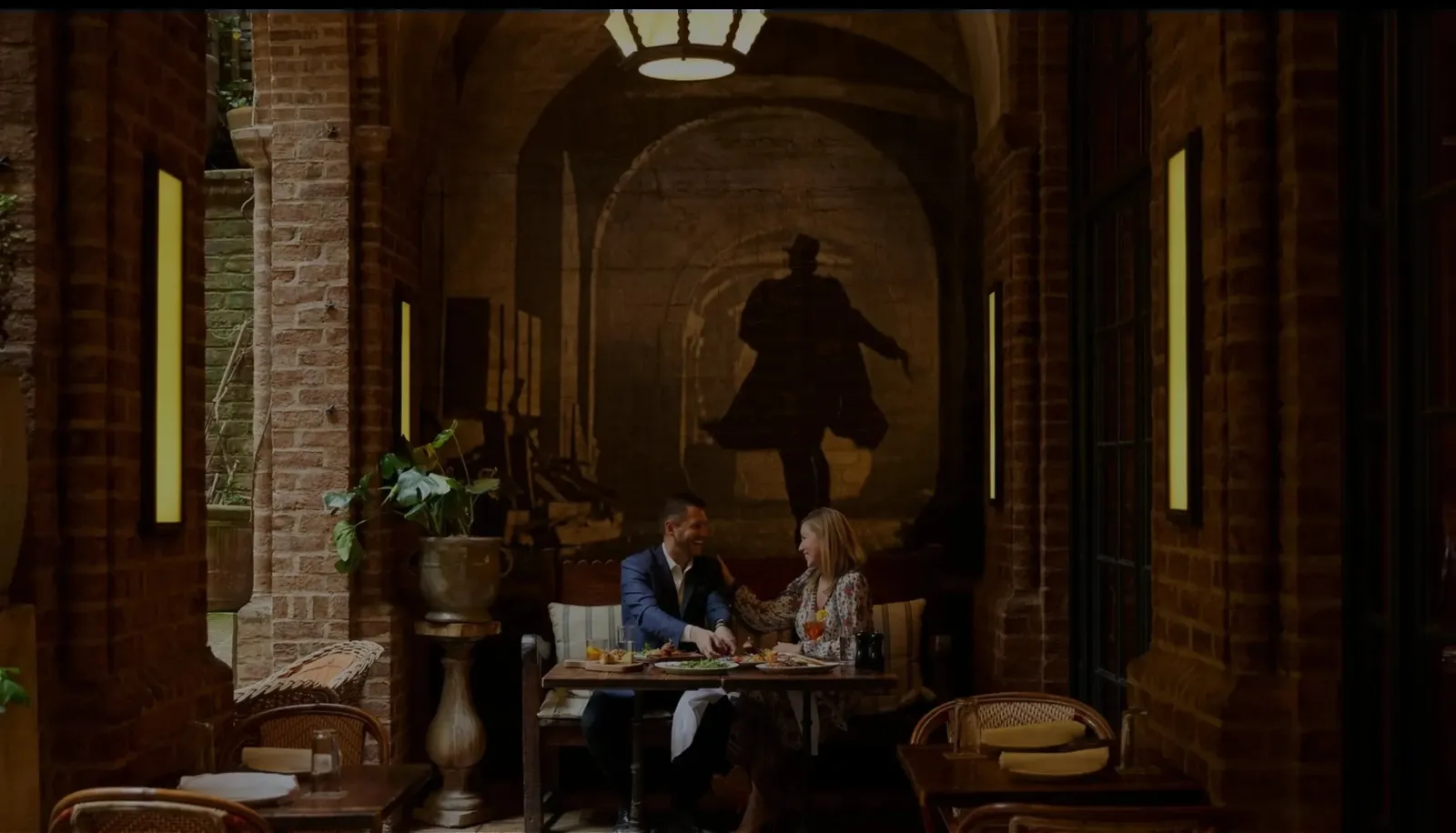 A couple at dinner under the Colonnade’s arches