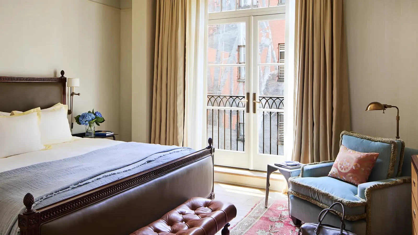 The Courtyard King with its bed and armchair below the French doors to the courtyard