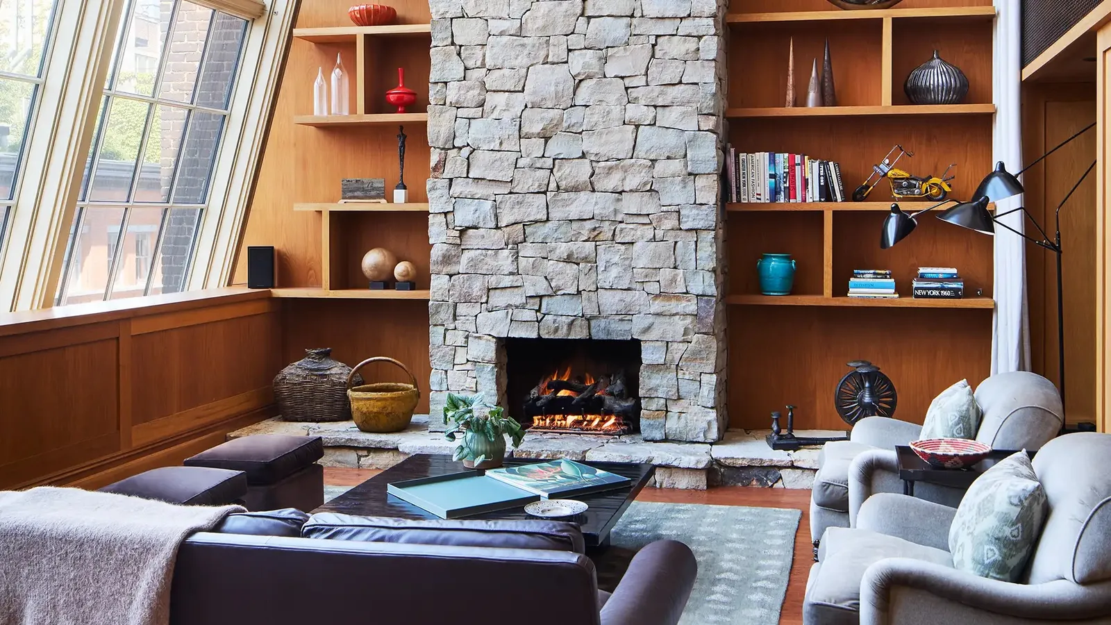 The North Moore Duplex living room, sofas and bookshelves under the tall windows