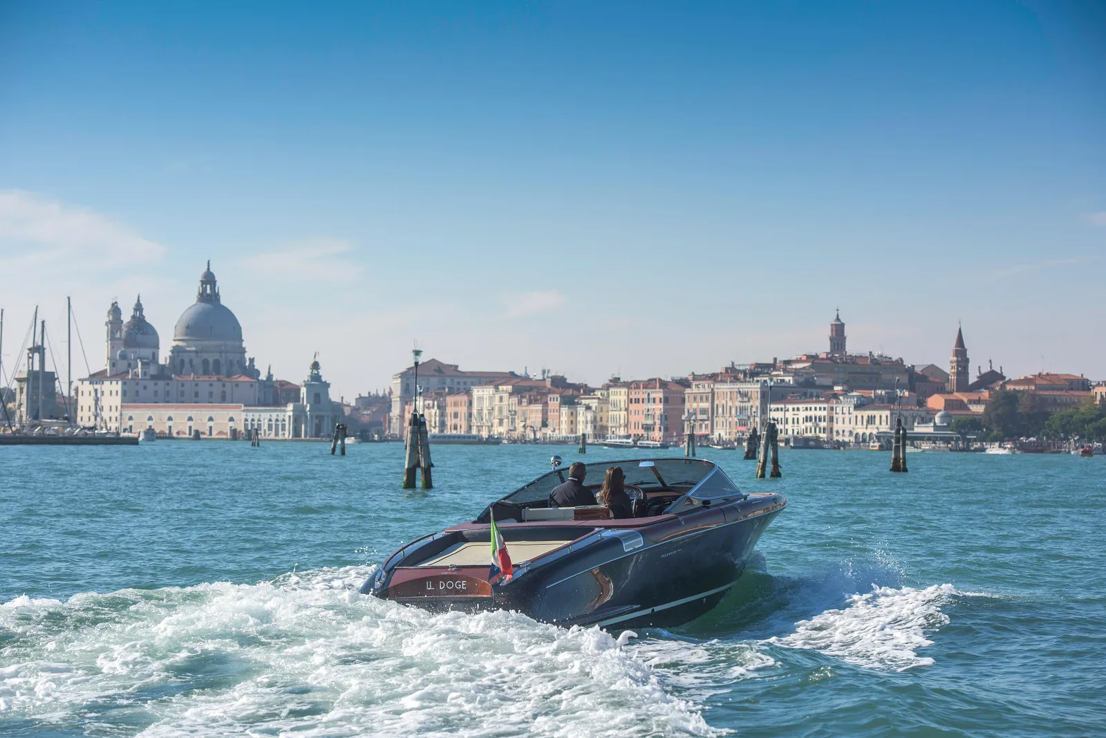 The hotel’s Riva speedboat at speed in St Mark’s Basin, the Salute and Venice’s bell towers behind it.