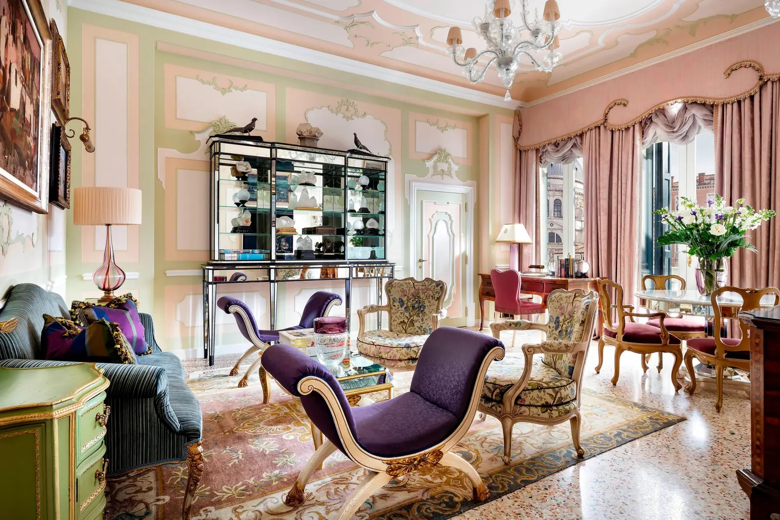 The Royal Suite sitting room: pink and green stuccoed walls, a purple daybed, a cabinet of porcelain and the windows onto the canal.