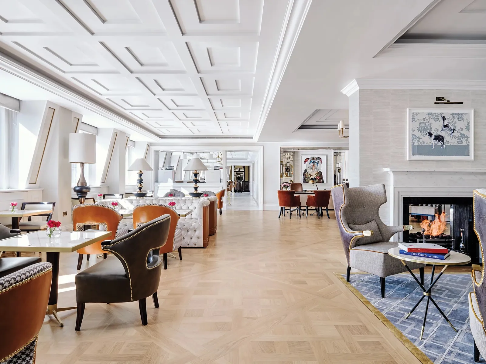 The Langham Club on the third floor: pale parquet, leather armchairs and a lit fireplace