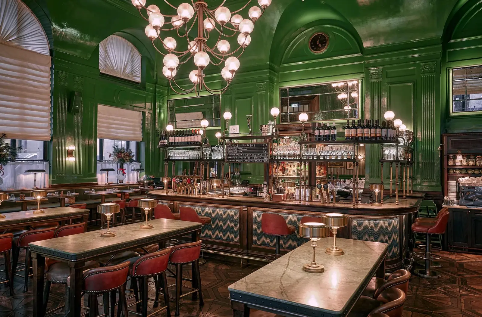The Wigmore: glossy green walls, globe chandeliers and a long bar with red stools