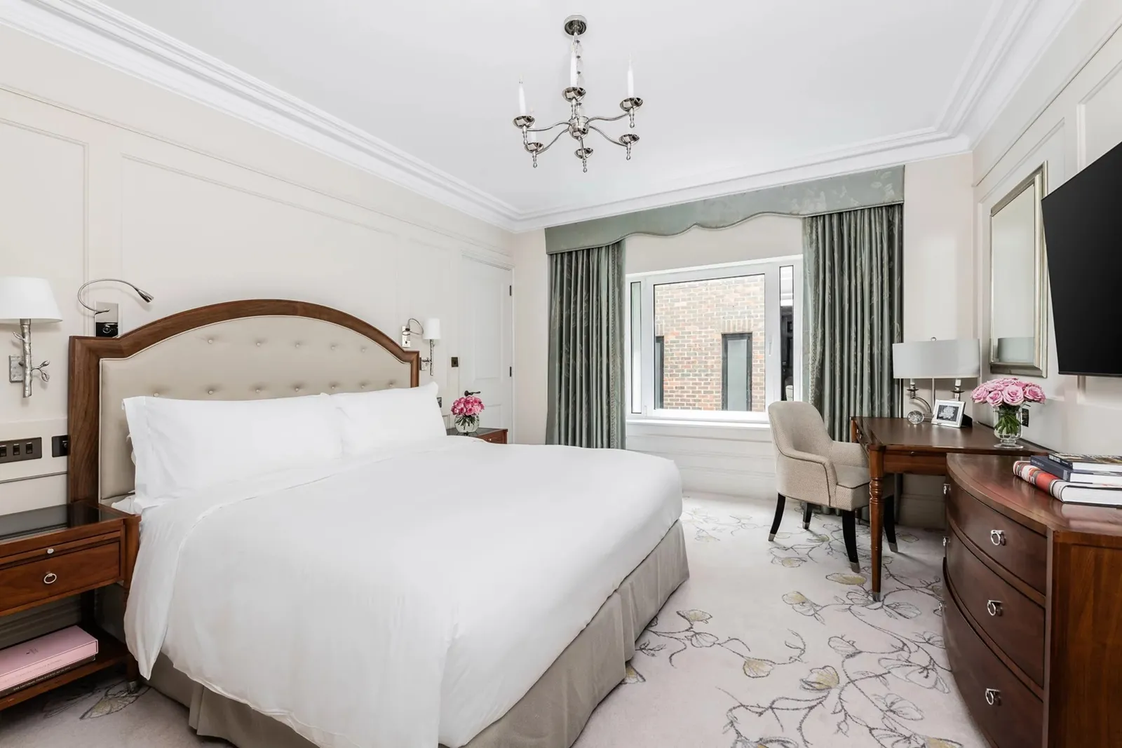 A Classic Room: a double bed with a wooden headboard and white linen, a writing desk under the window, pale panelled walls