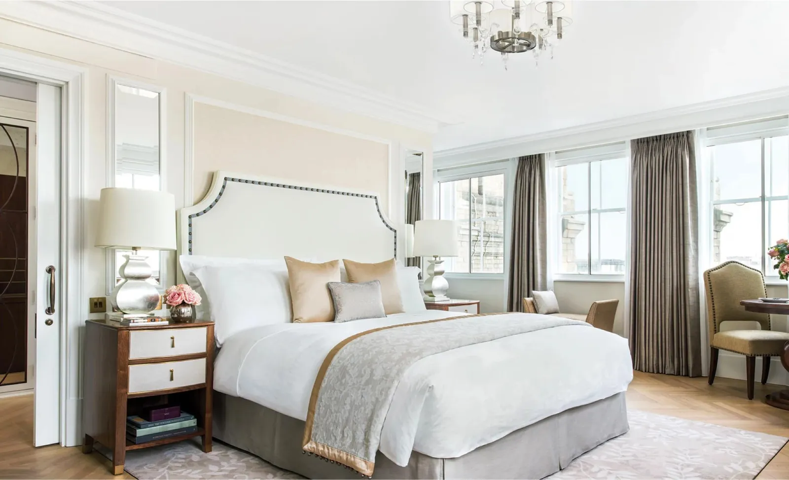 A Club Executive Room: a king bed with an upholstered headboard, silver lamps and a wall of windows